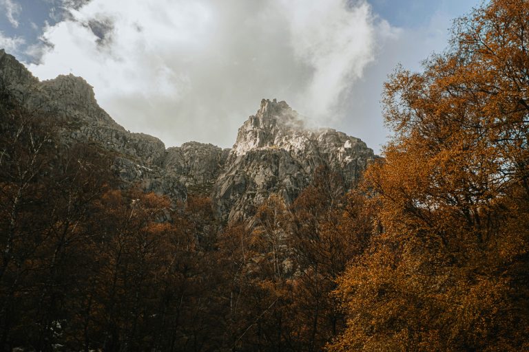 Majestic rocky mountains surrounded by autumn foliage in Manteigas, Portugal.
